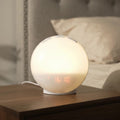 Réveil lumineux Aubéa allumé en lumière blanche chaude sur une table de chevet